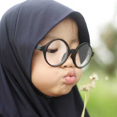 Little Asian Muslim Girl Playing in the Park Portrait of little Asian muslim baby girl wearing hijab and eyeglasses playing in the park